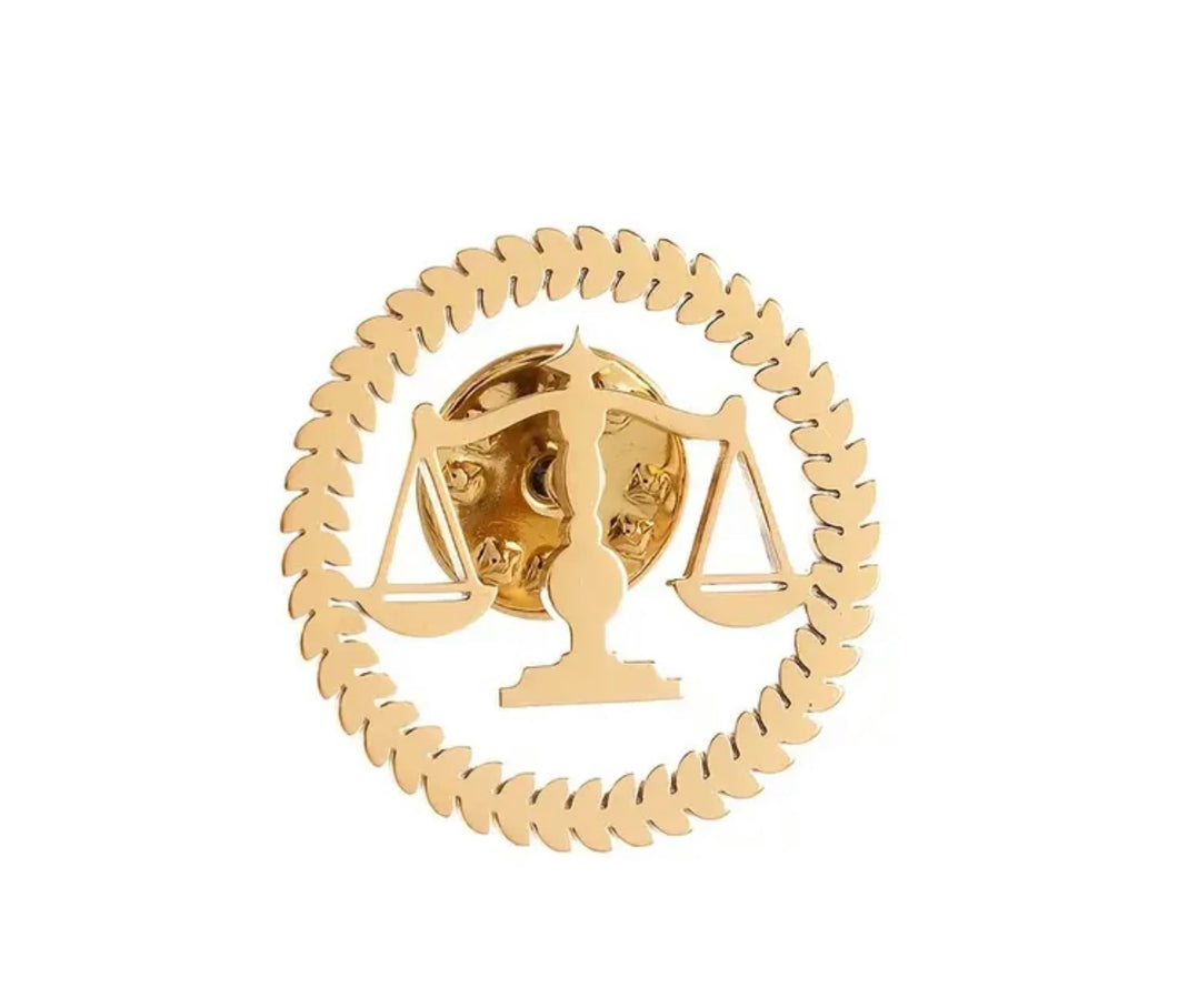 Pin con símbolo de balanza